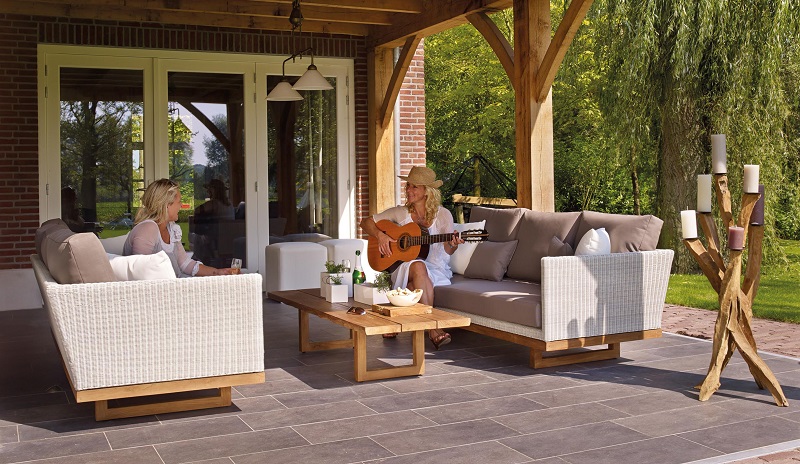 Outdoor patio furniture with two women relaxing under a covered terrace